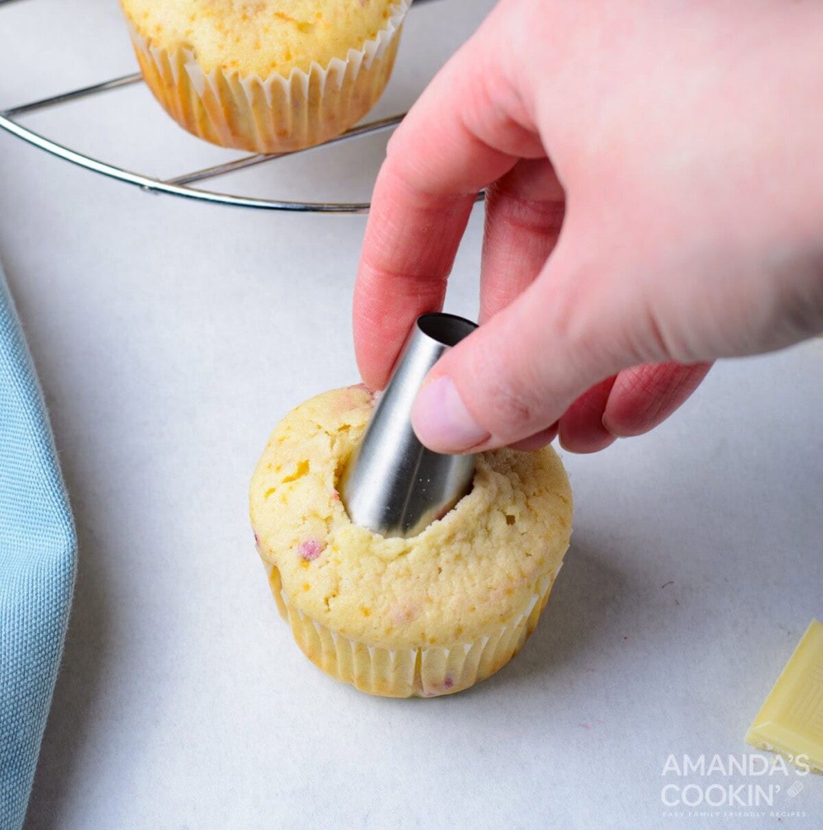 using a piping tip to make a hole in a cupcake