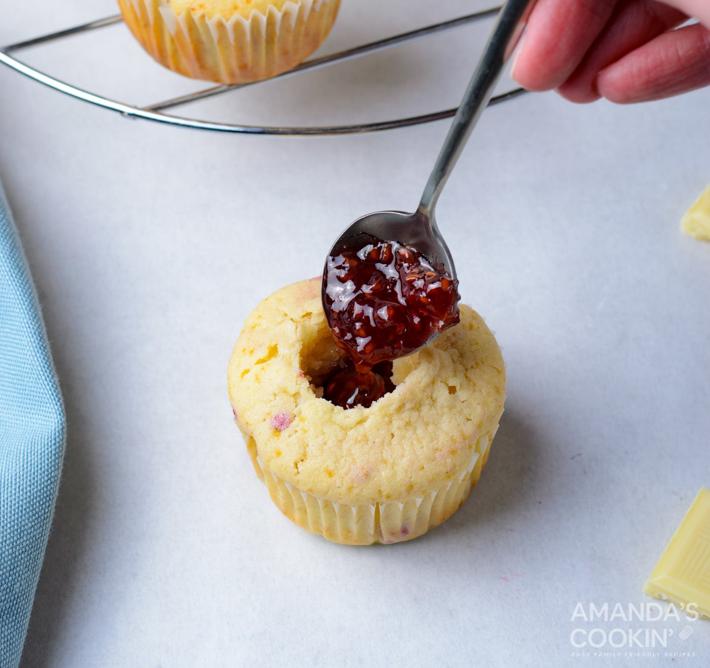 filling cupcake with raspberry jam
