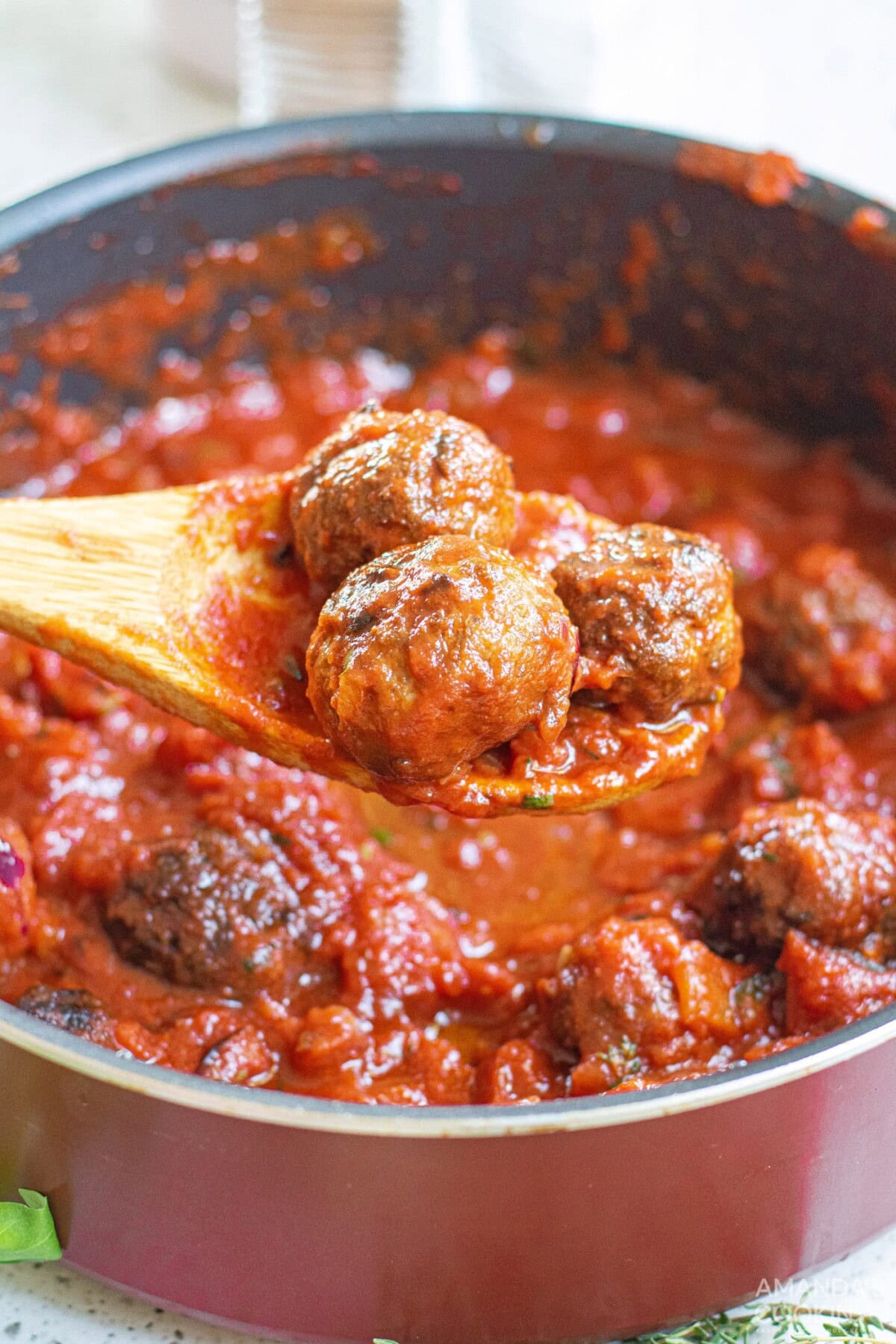 lifting meatballs from marinara