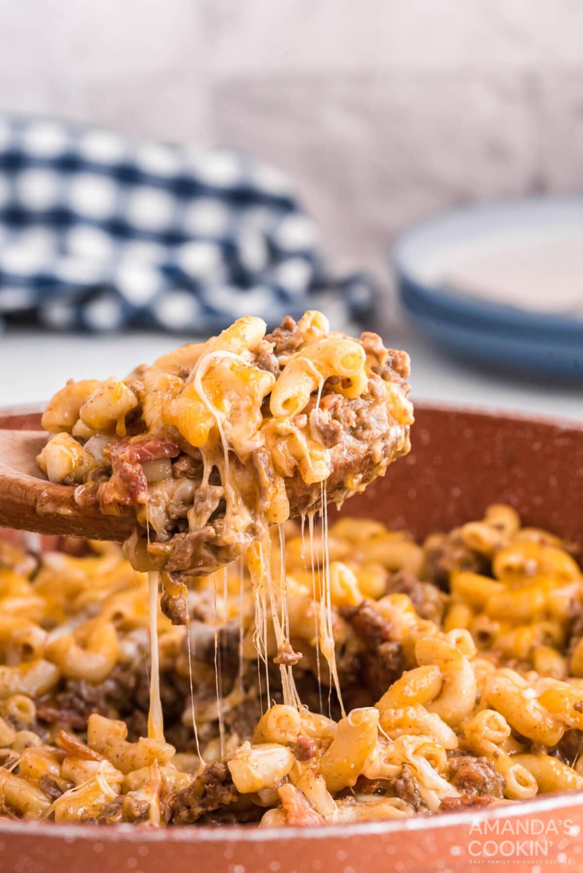 lifting a spoon of bacon cheeseburger casserole