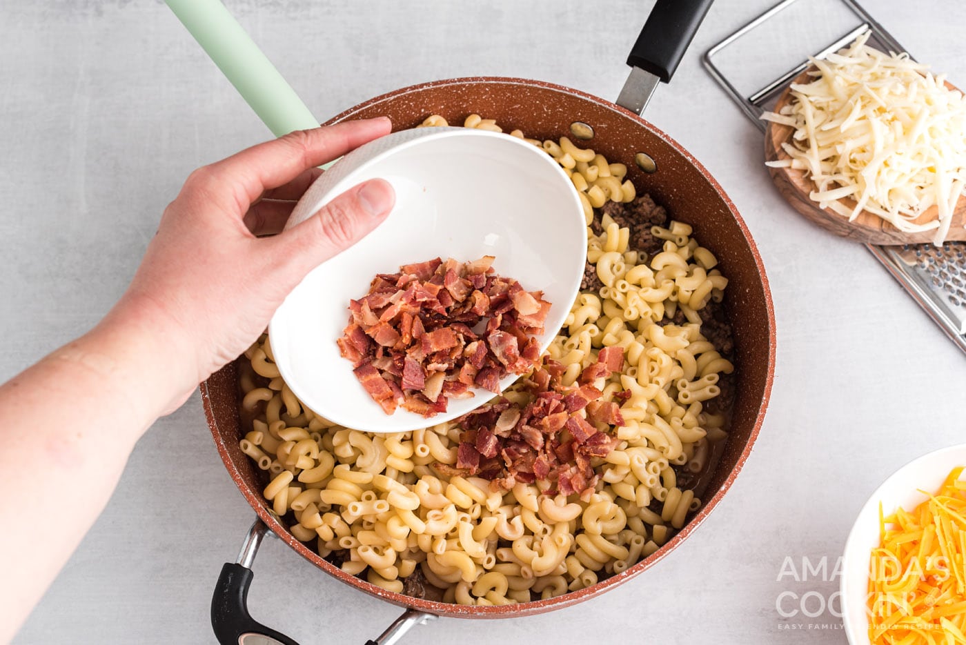 Adding bacon to skillet with pasta and ground beef