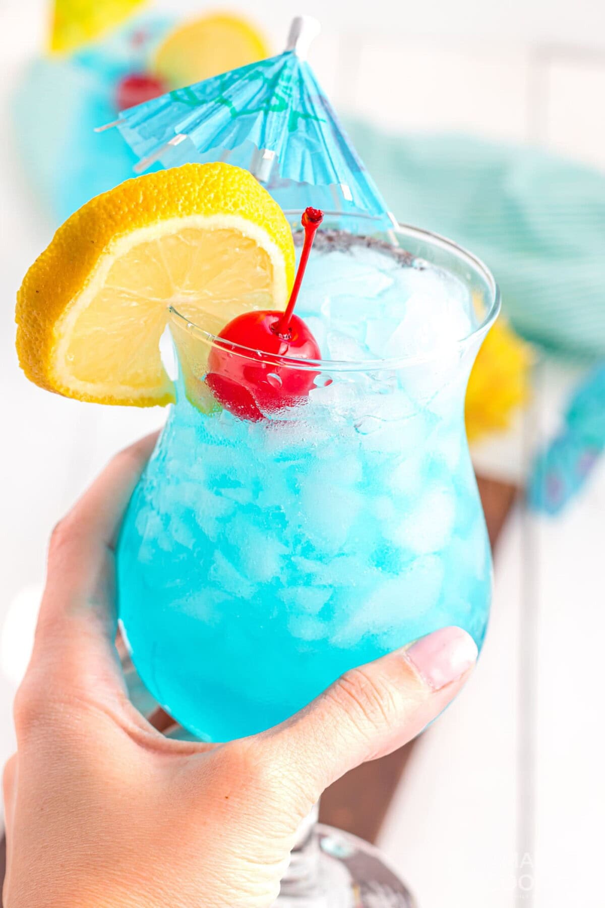 holding a Blue Lagoon Cocktail