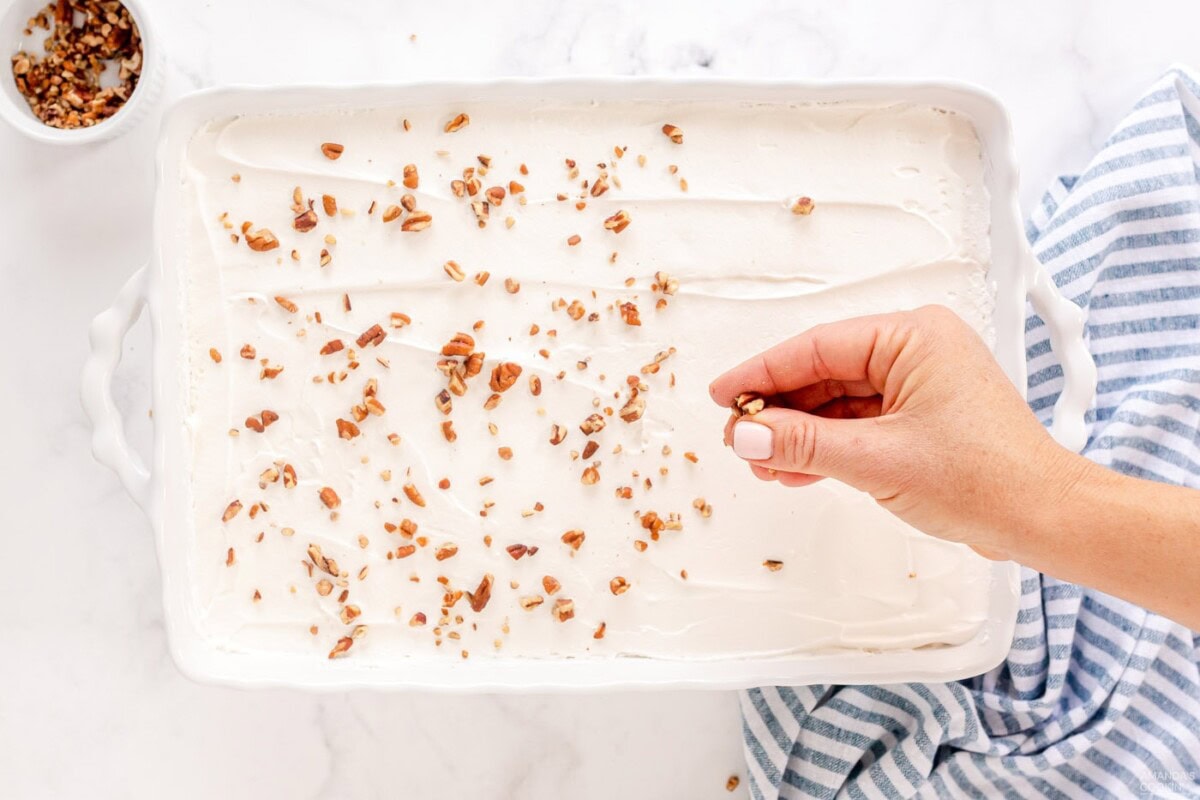 hand sprinkling on chopped pecans