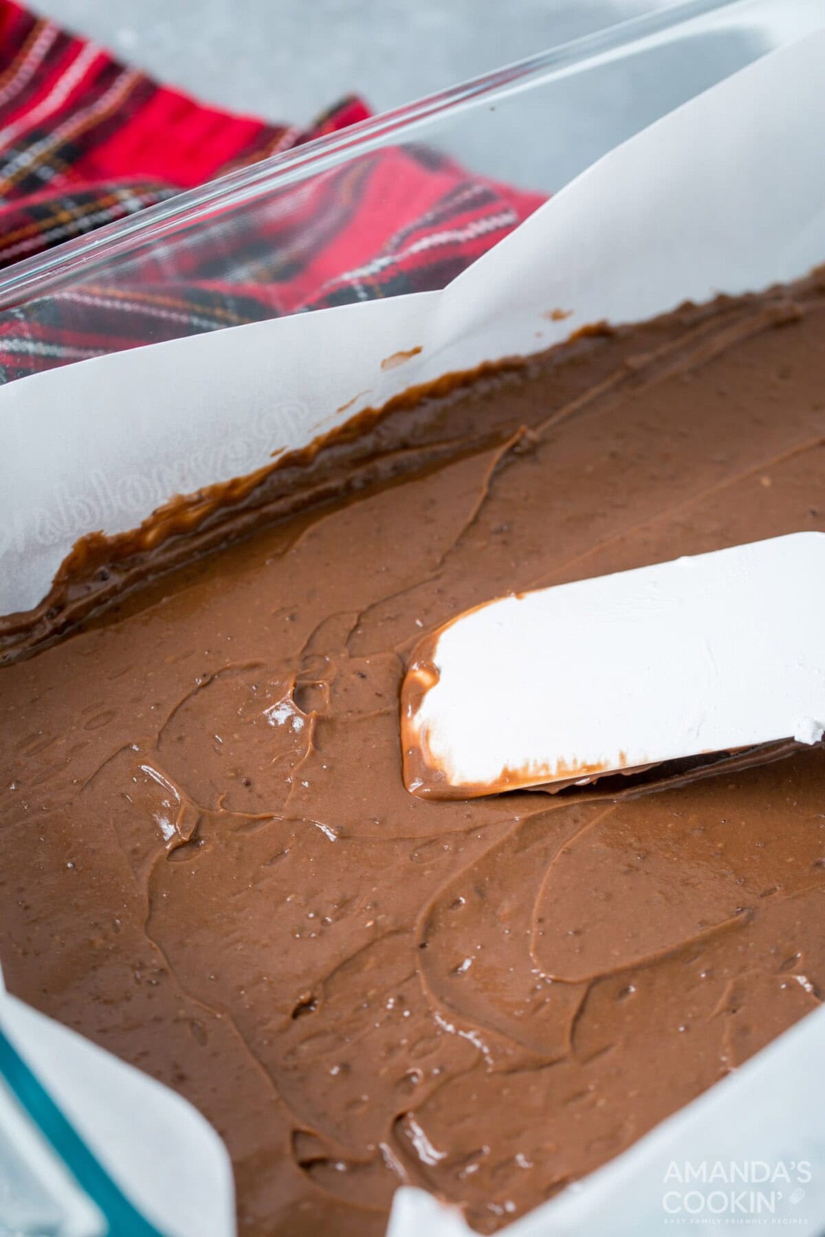 rubber spatula smoothing chocolate pudding into pan