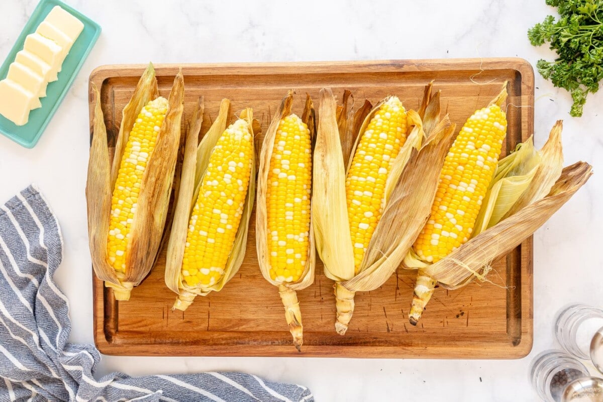 peeled corn on the cob on a cutting board