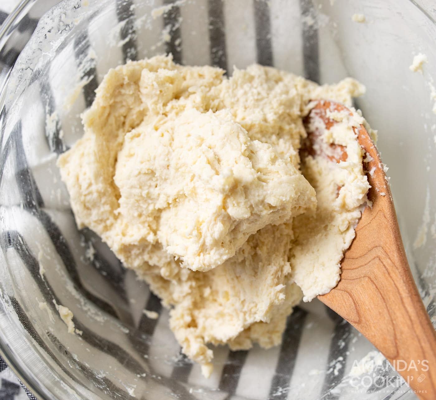 pie dough in a bowl with wooden spoon