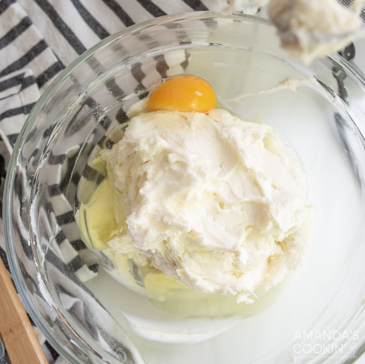 lemon juice, vanilla extract, and an egg in bowl with cream cheese mixture