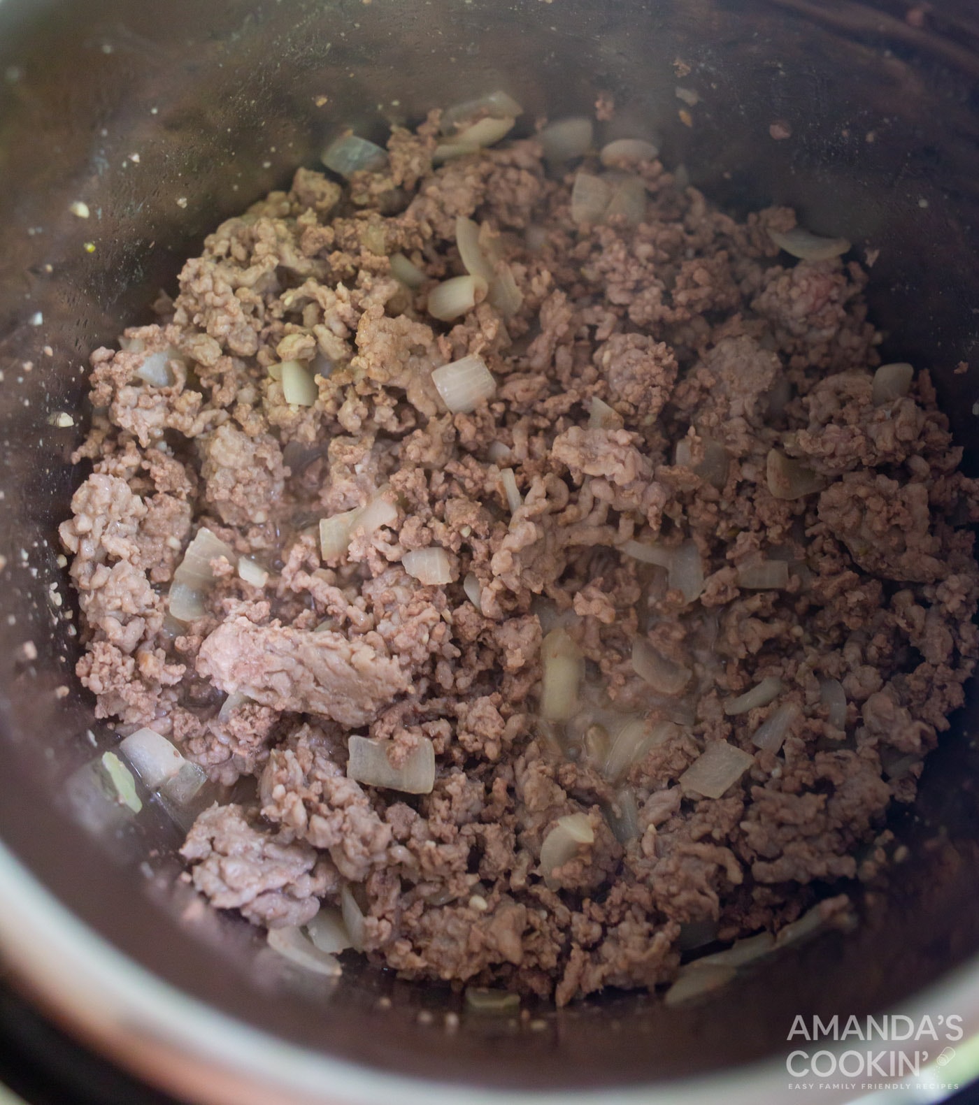 pork, beef, and onions sauteeing in the instant pot