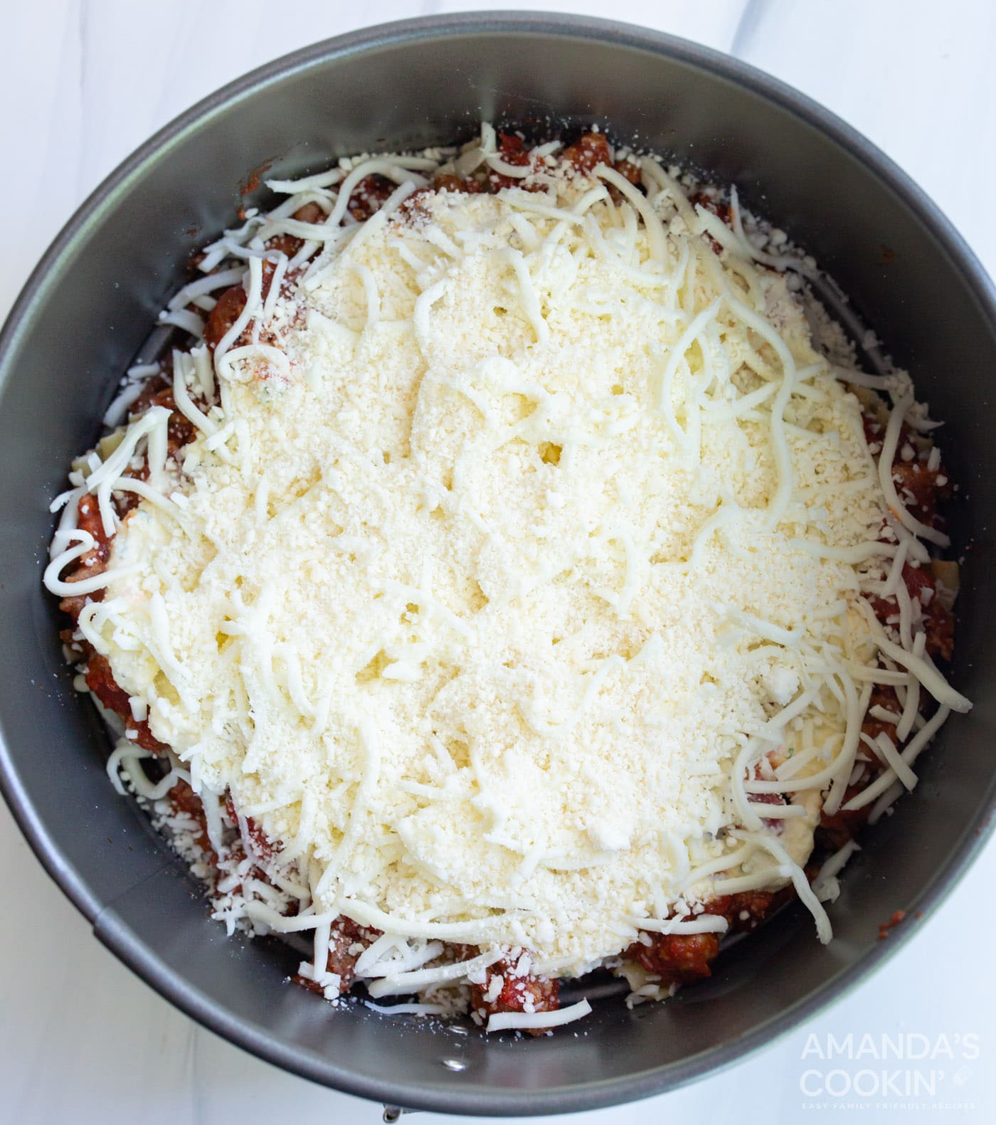 cheese on top of lasagna in springform pan