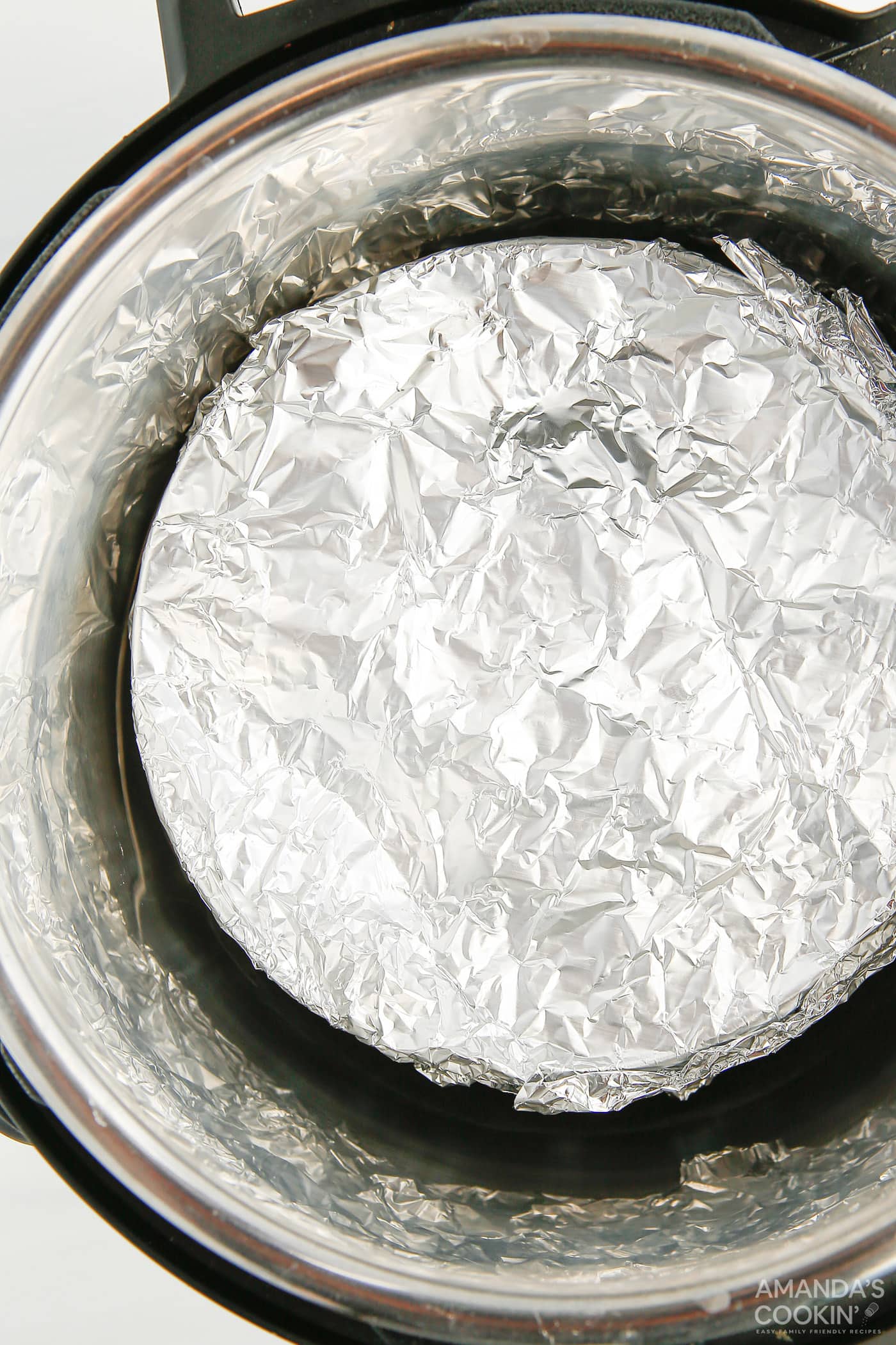 springform pan covered in aluminum foil in an instant pot