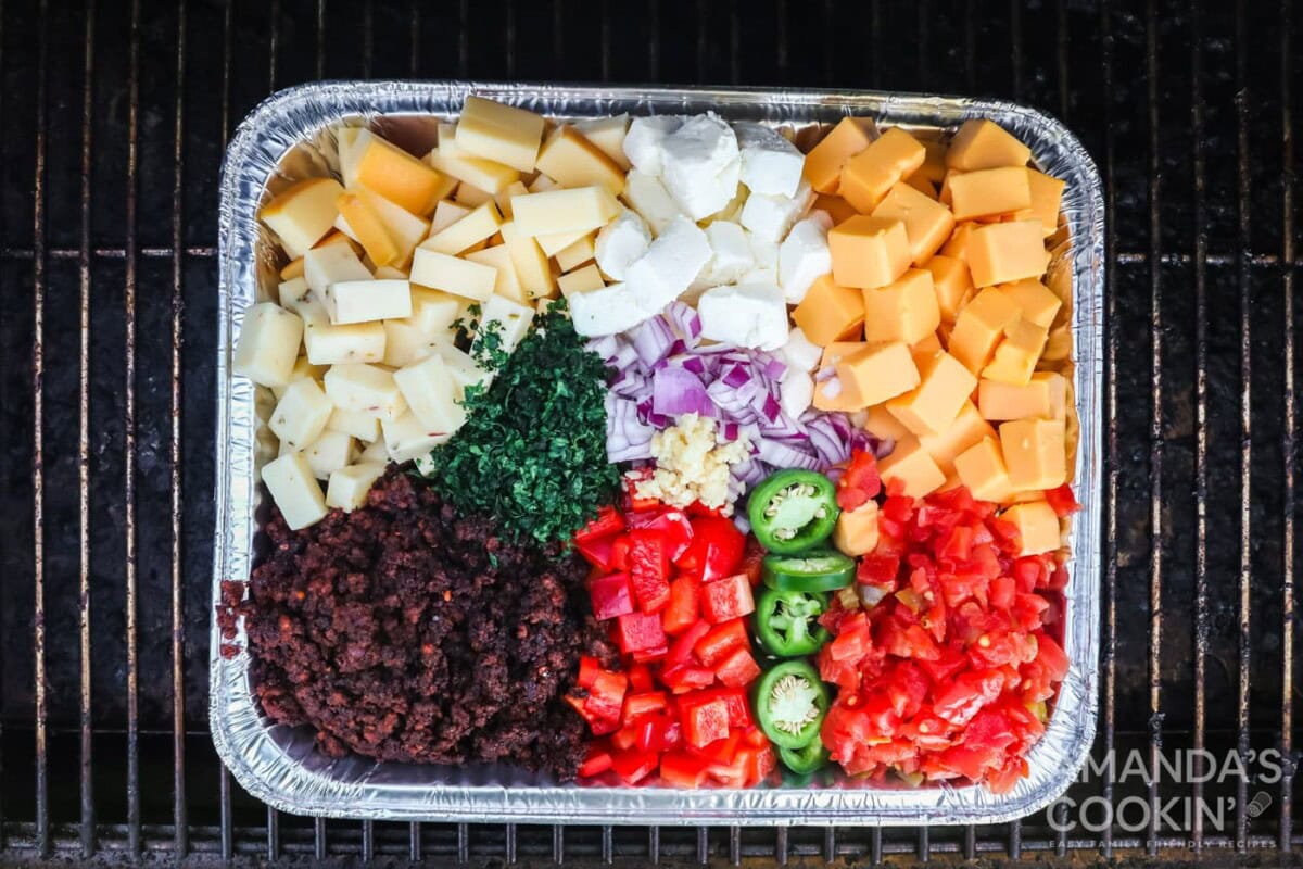 queso dip ingredients in a 13x9 foil pan