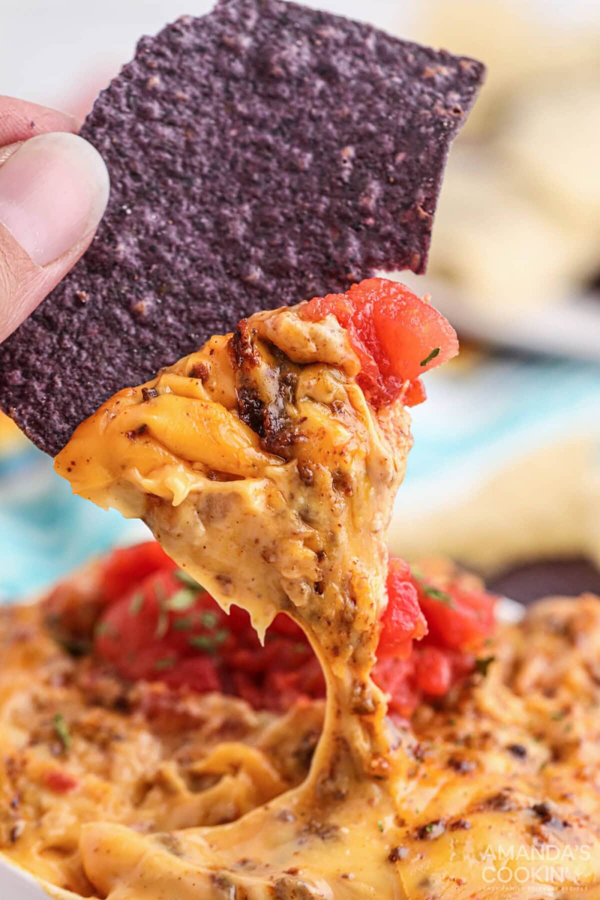 dipping chip into Smoked Queso Dip