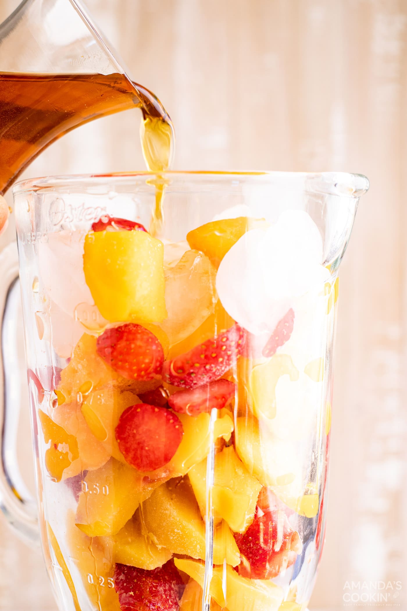 Pouring rum into blender with fruit