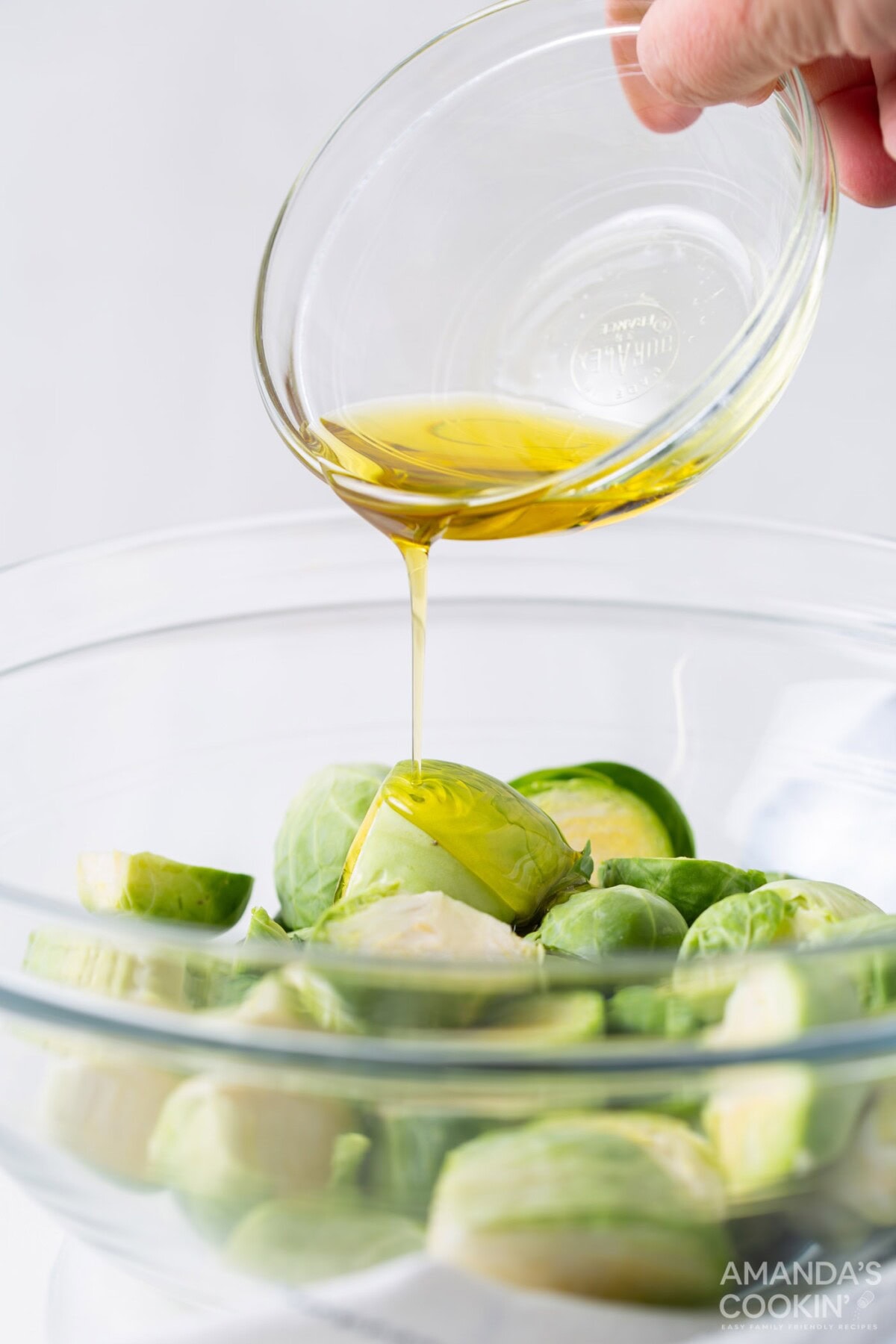 pouring olive oil onto brussels sprouts