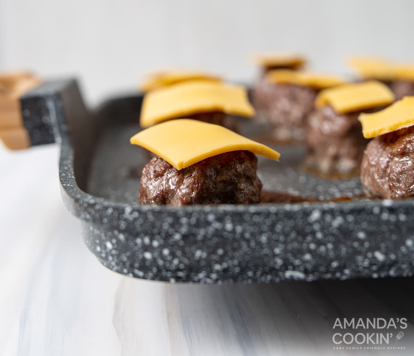 mini cheese slices on top of meatballs