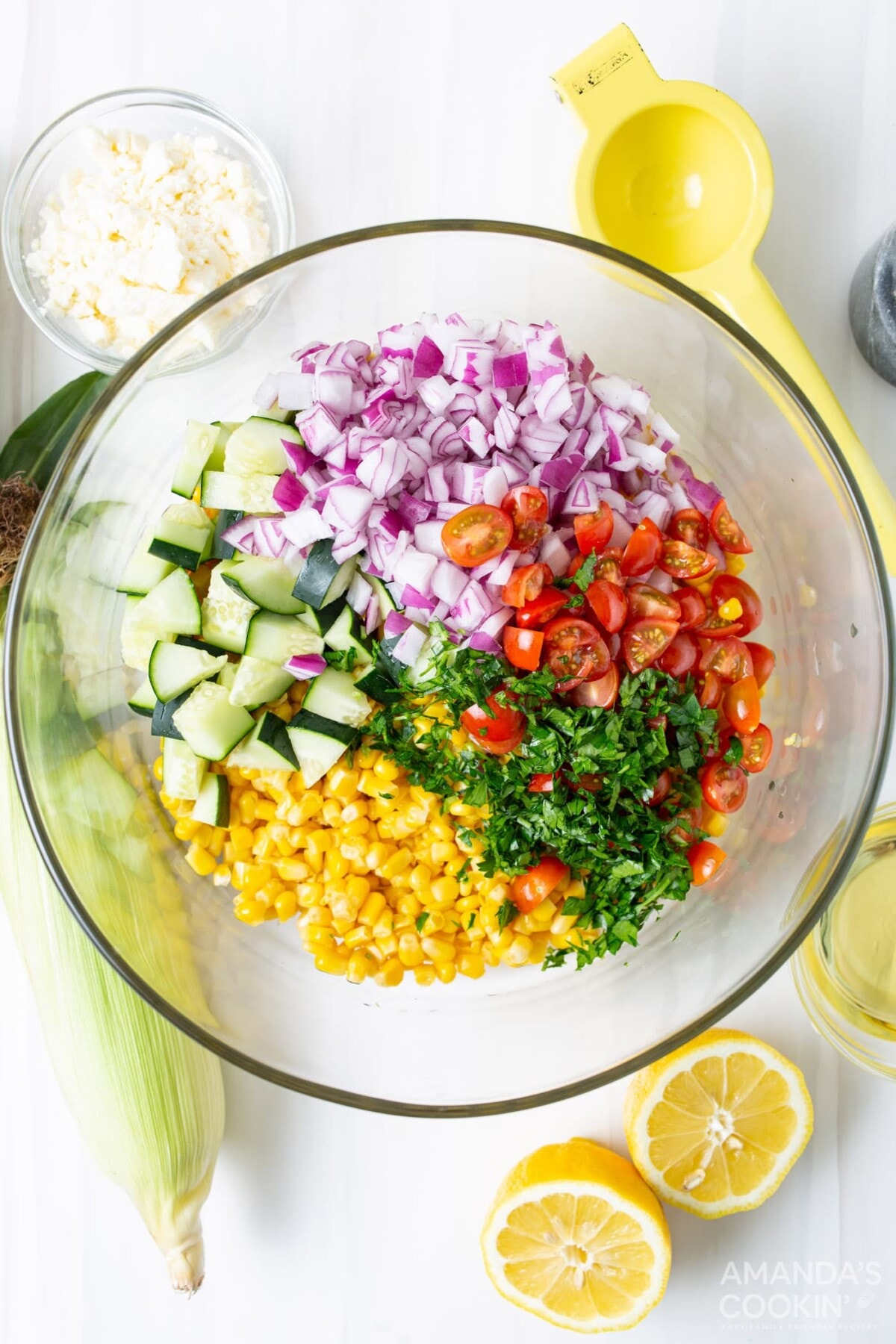 mixing bowl with corn, tomatoes, basil, cucumber, and red onion