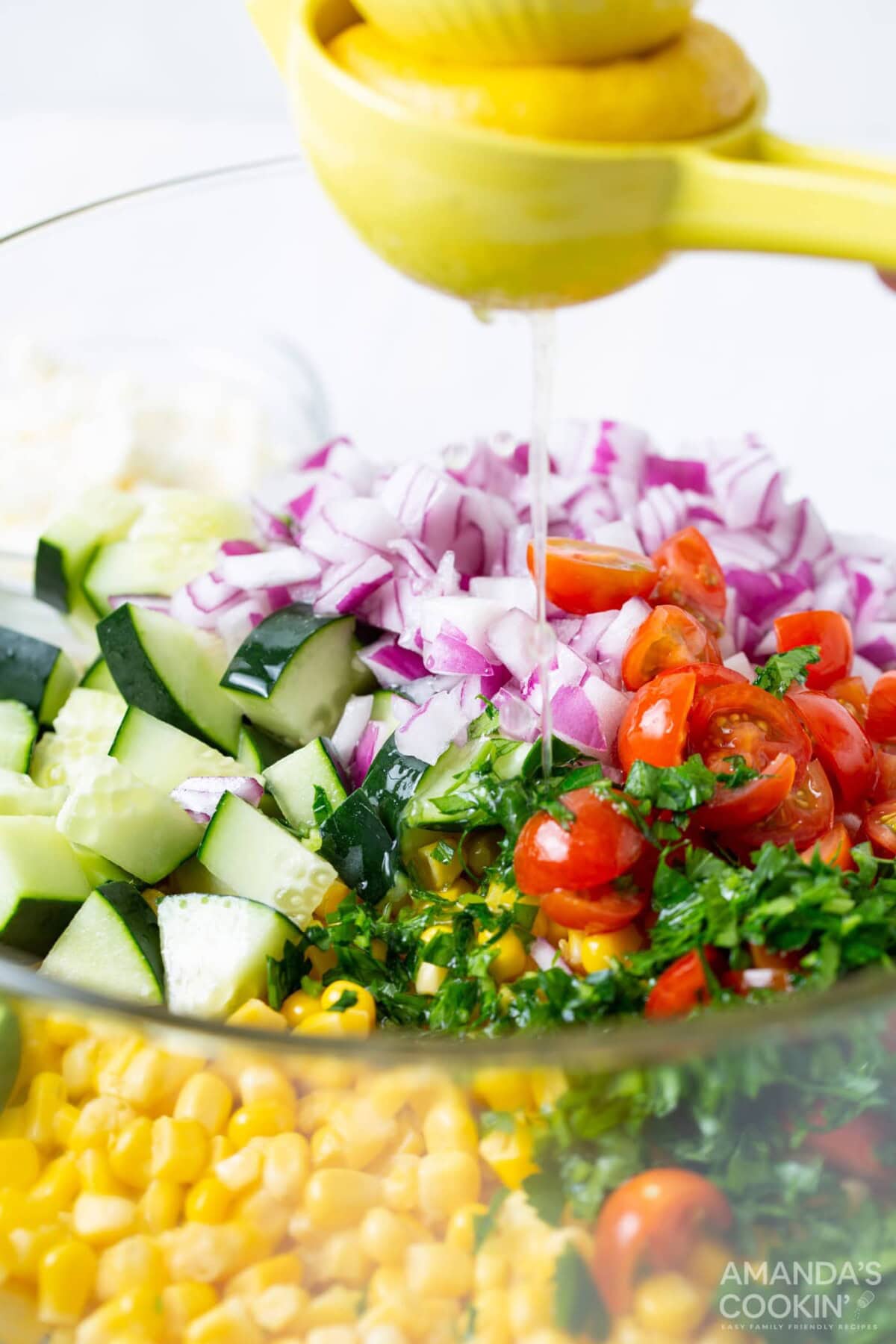 squeezing lemon juice onto corn salad