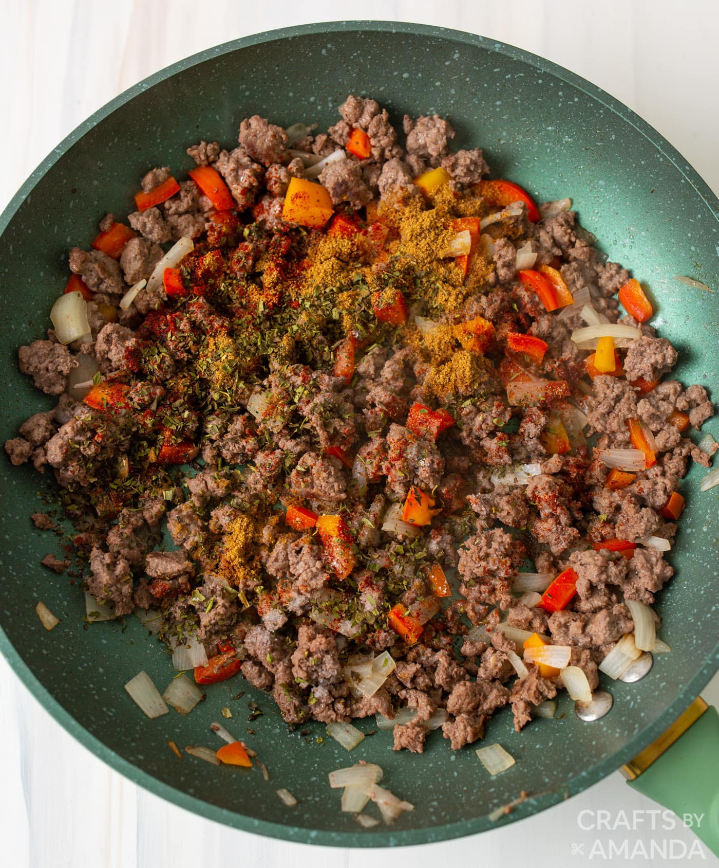 ground beef, peppers, garlic, seasonings, and onions in a skillet