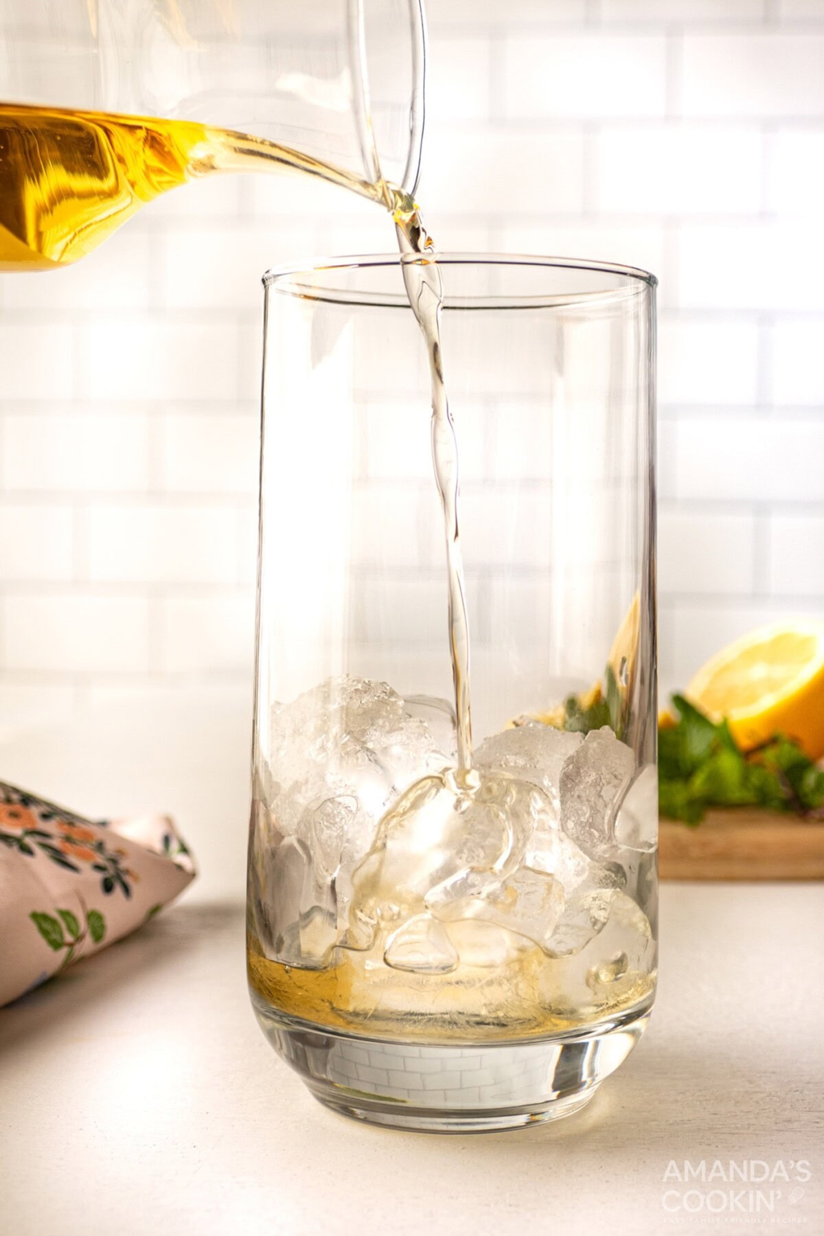 pouring whiskey into glass with ice