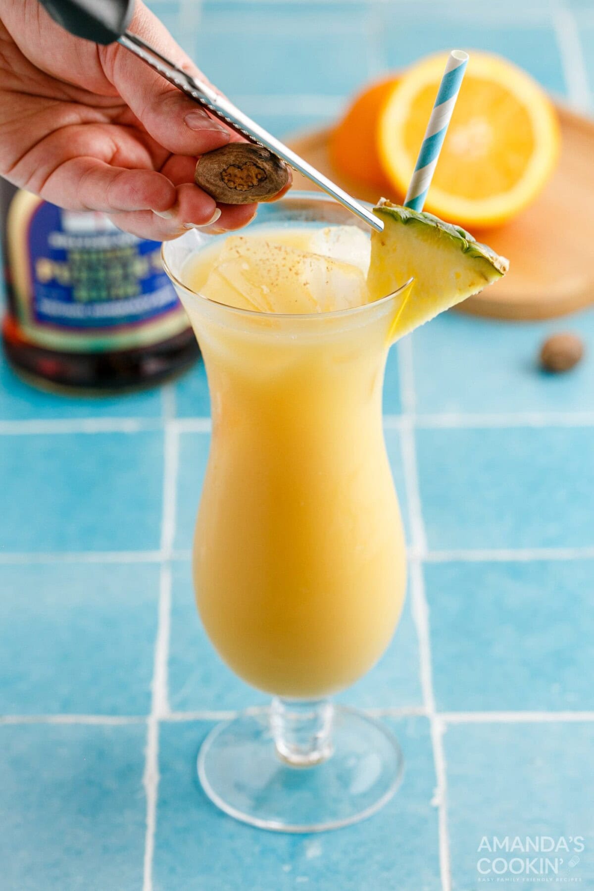 adding pineapple wedge garnish to painkiller cocktail