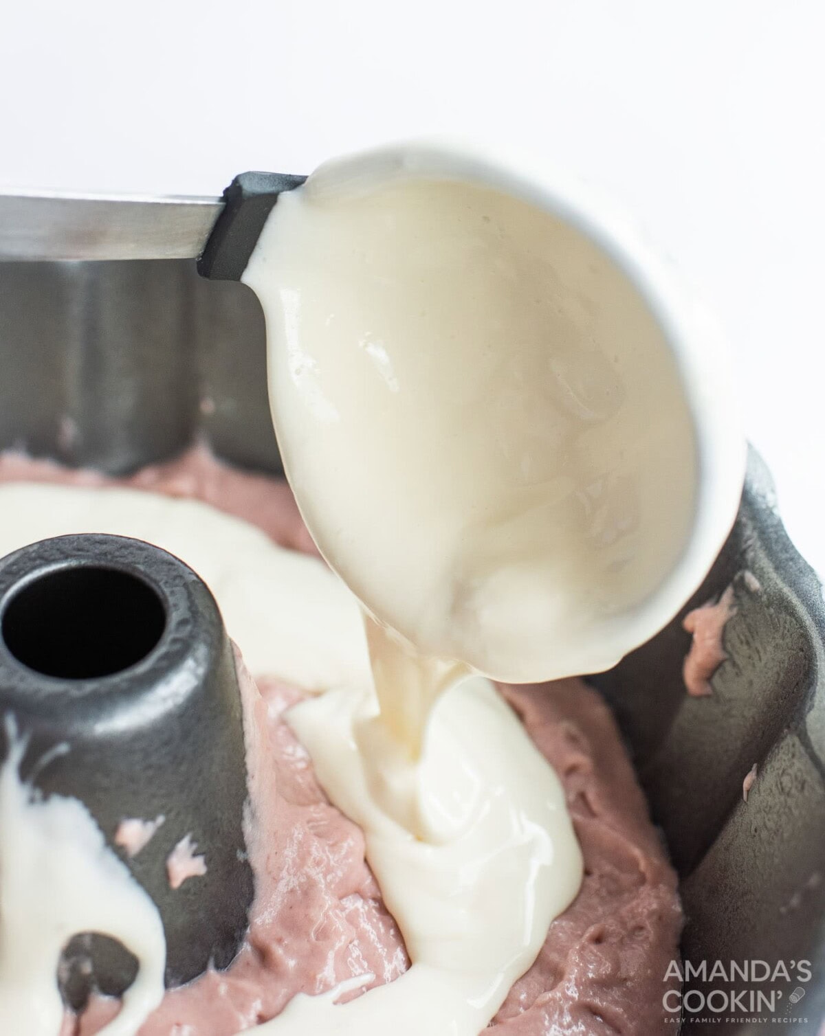 adding cheesecake mixture to pan