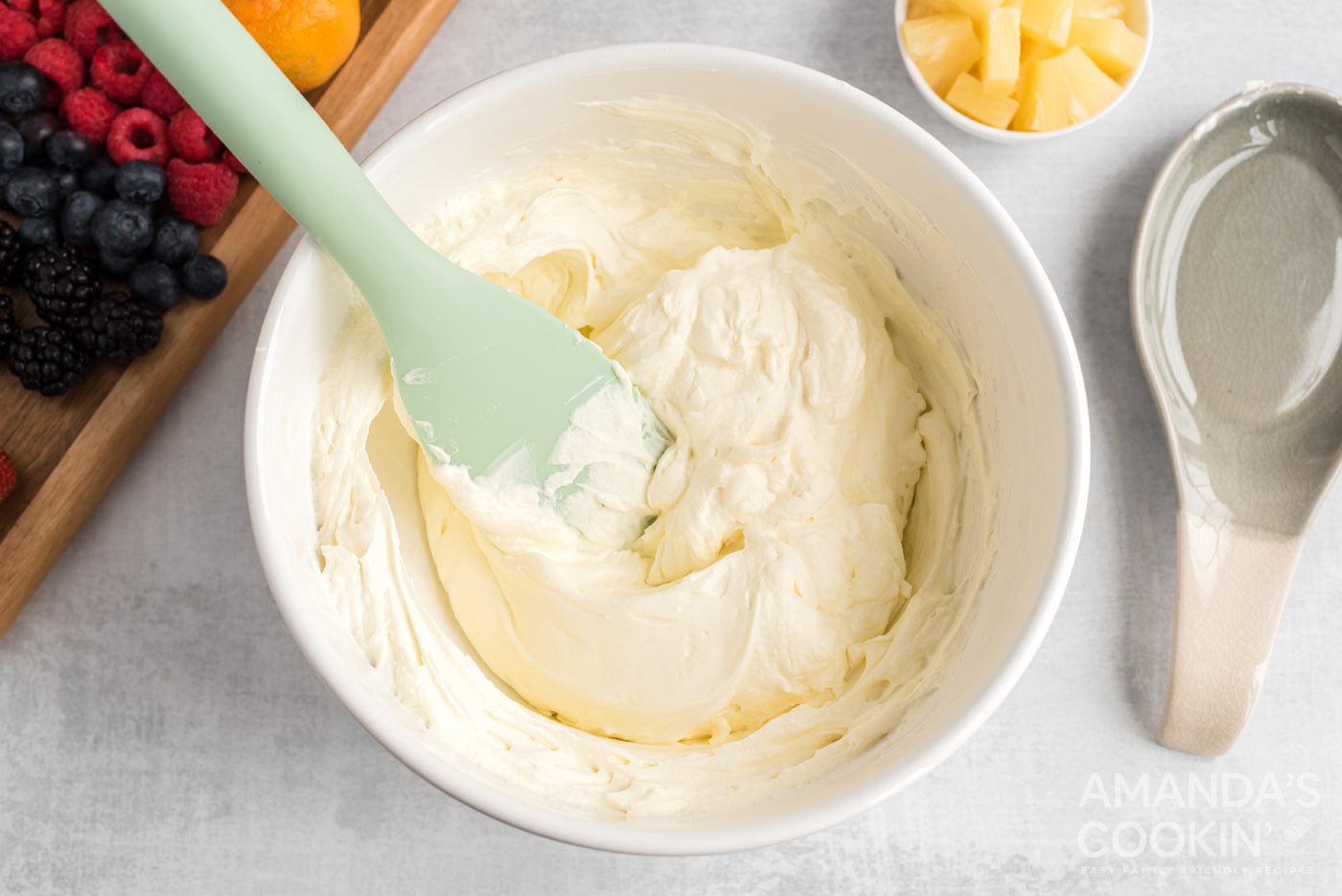 rubber spatula folding in whipped topping to cream cheese mixture