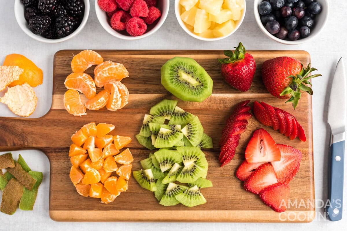 mandarin oranges, kiwi, and strawberries on cutting board