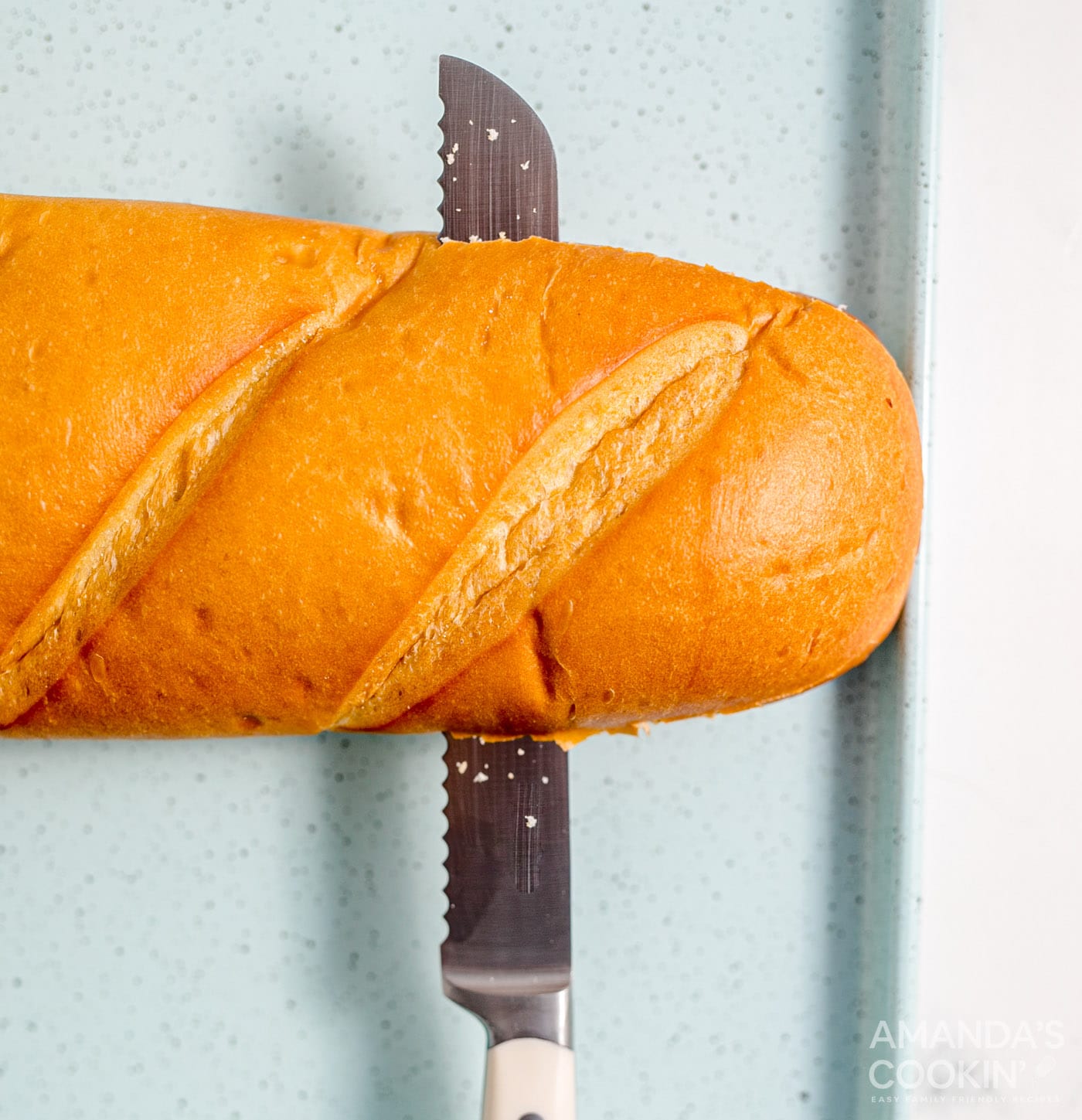 knife slicing french bread in half