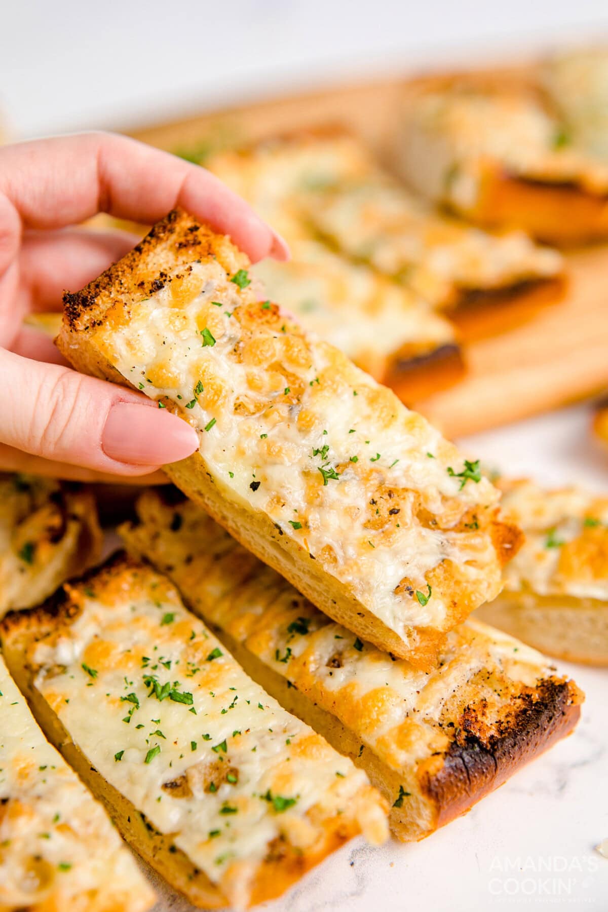 hand picking up a slice of Garlic Bread