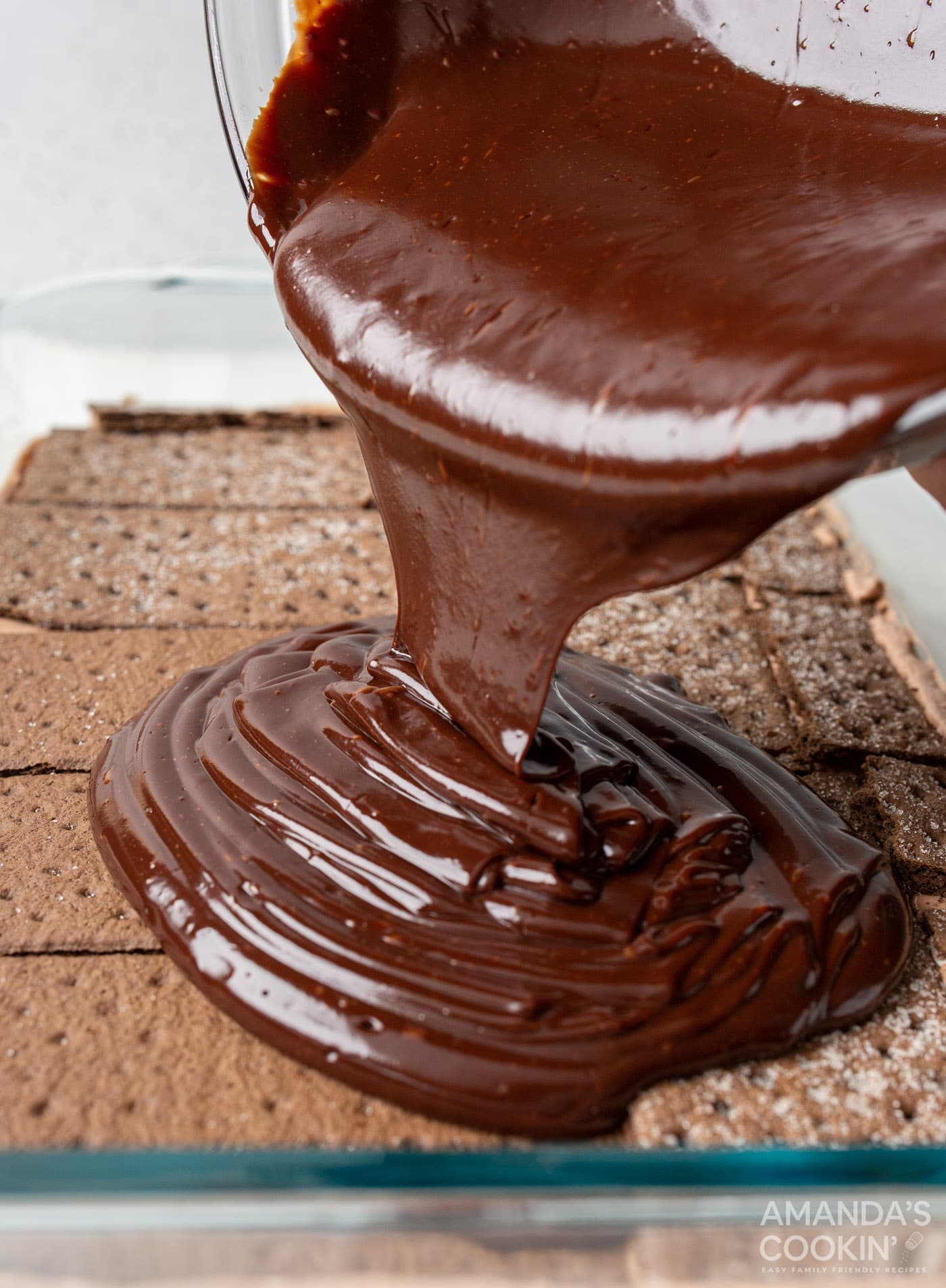pouring ganache over chocolate graham crackers