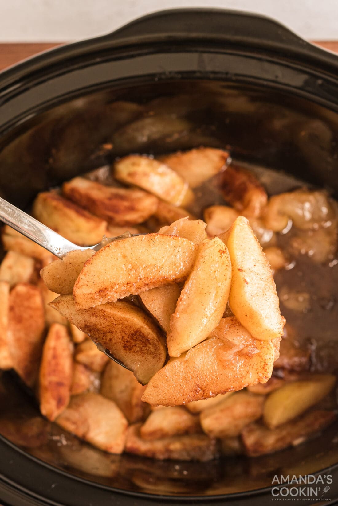 spooning out some Crockpot Cinnamon Apples