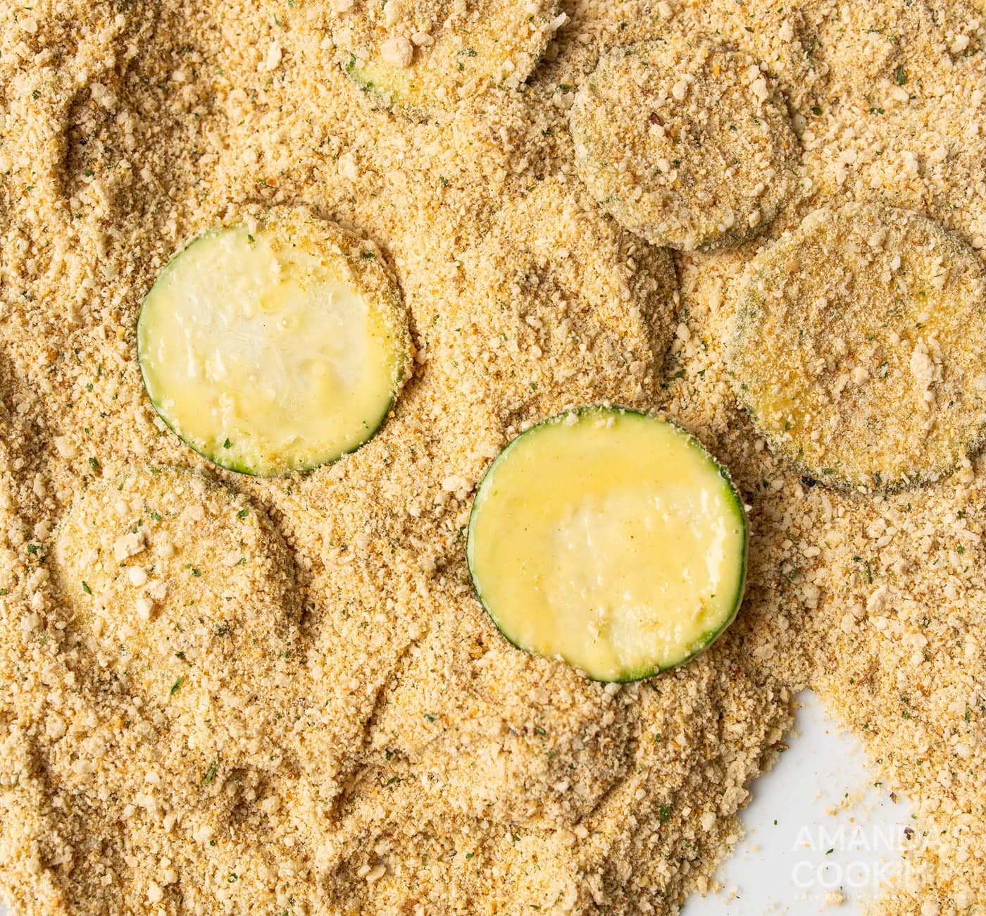 dipping zucchini slices in breadcrumbs and parmesan cheese mixture