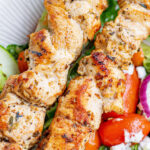 Greek Chicken Kabobs on plate with salad
