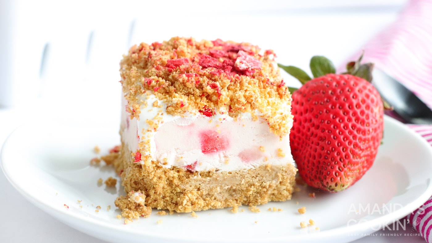 A creamy cheesecake center filled with fresh strawberries and a topping of graham cracker crumbs, co