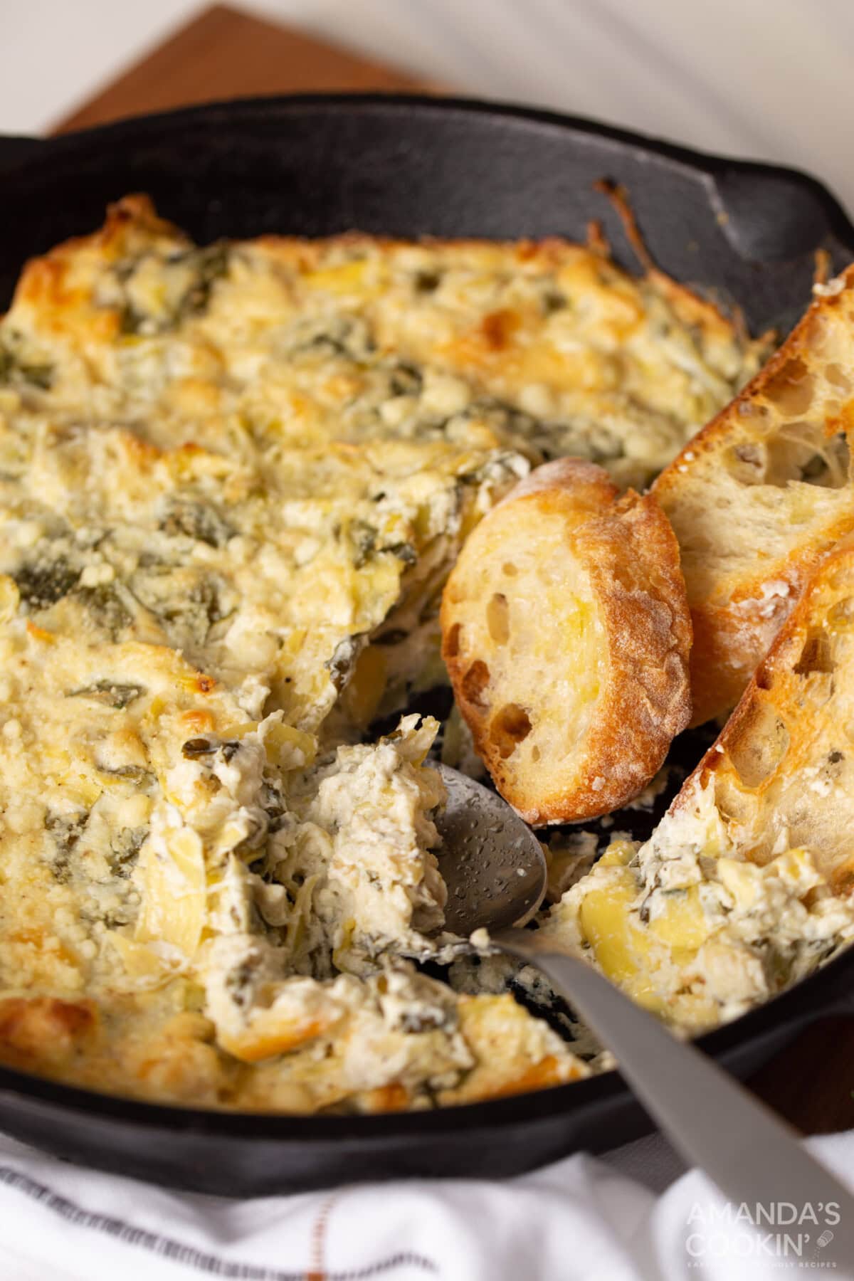 pan of Spinach Artichoke Dip with a spoon in it