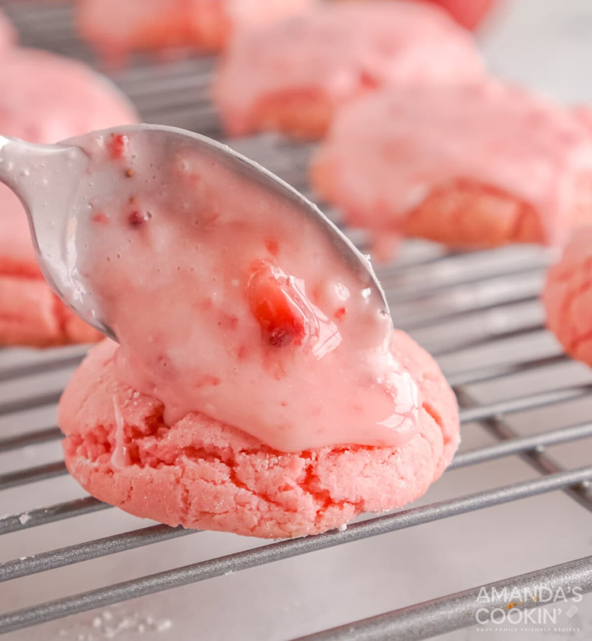 spooning strawberry glaze over cookies