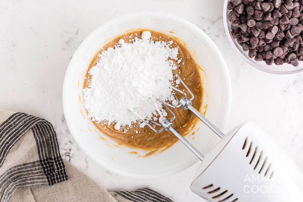 mixing powdered sugar into peanut butter mixture