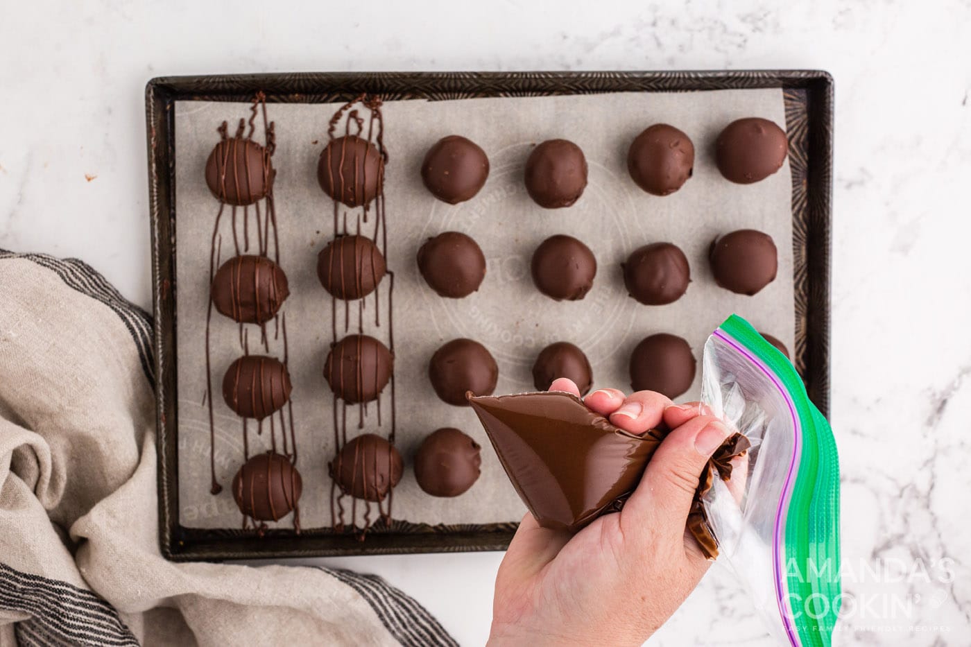piping chocolate drizzle over chocolate peanut butter balls