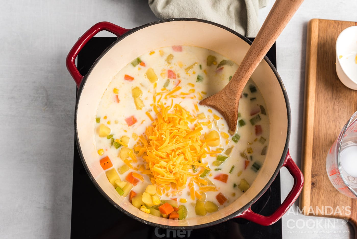 milk and cheese added to saucepan of corn chowder soup