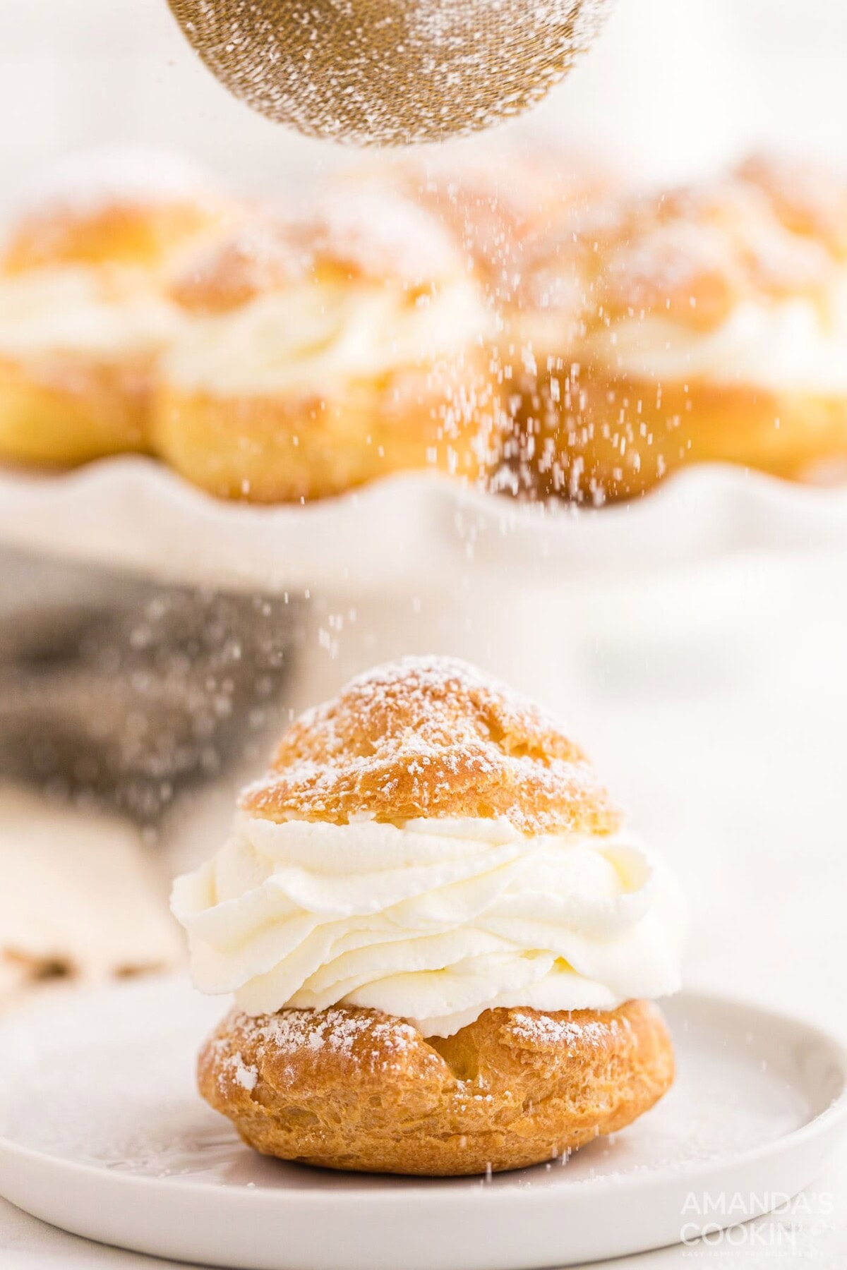 sifting powdered sugar on top of a Cream Puff