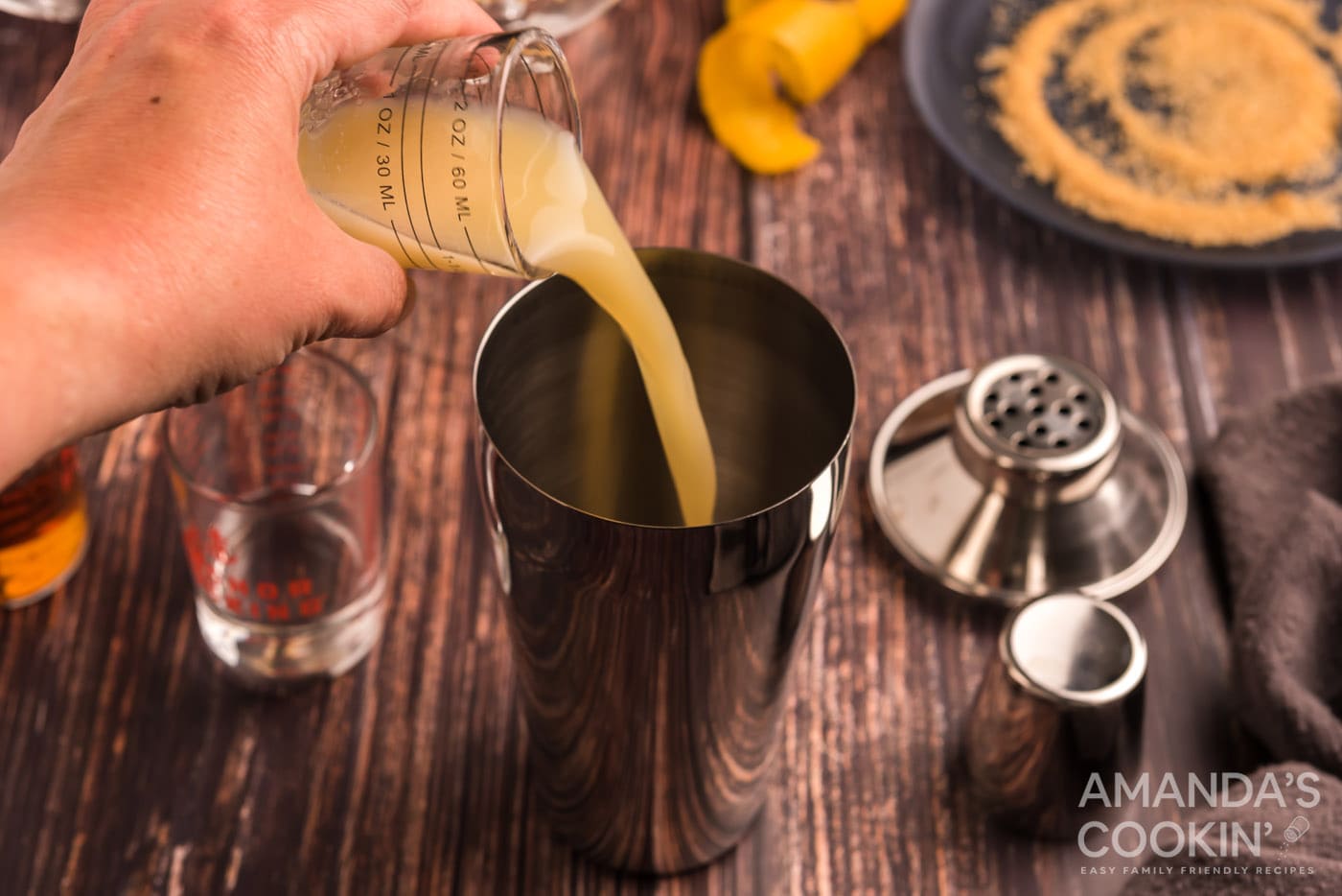 pouring lemon juice into cocktail shaker