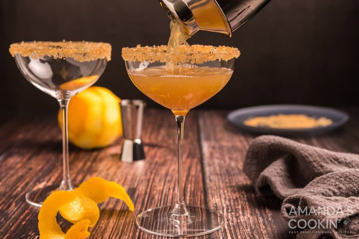 pouring sidecar cocktail into a glass