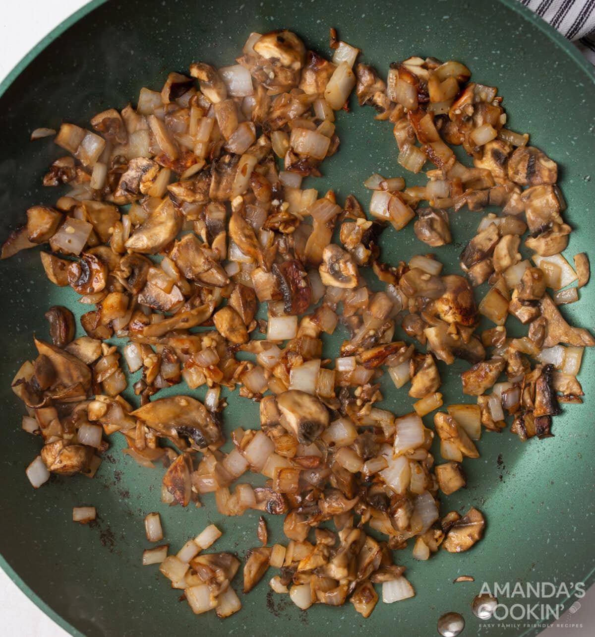 mushrooms and onion in a skillet with garlic