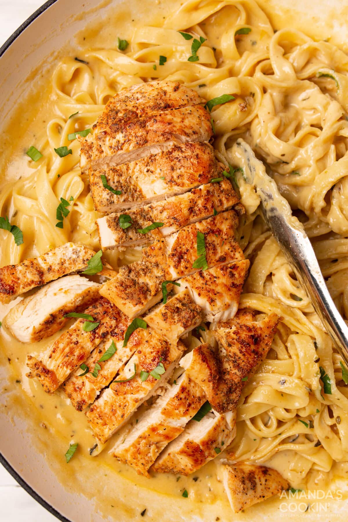Chicken Alfredo with tongs