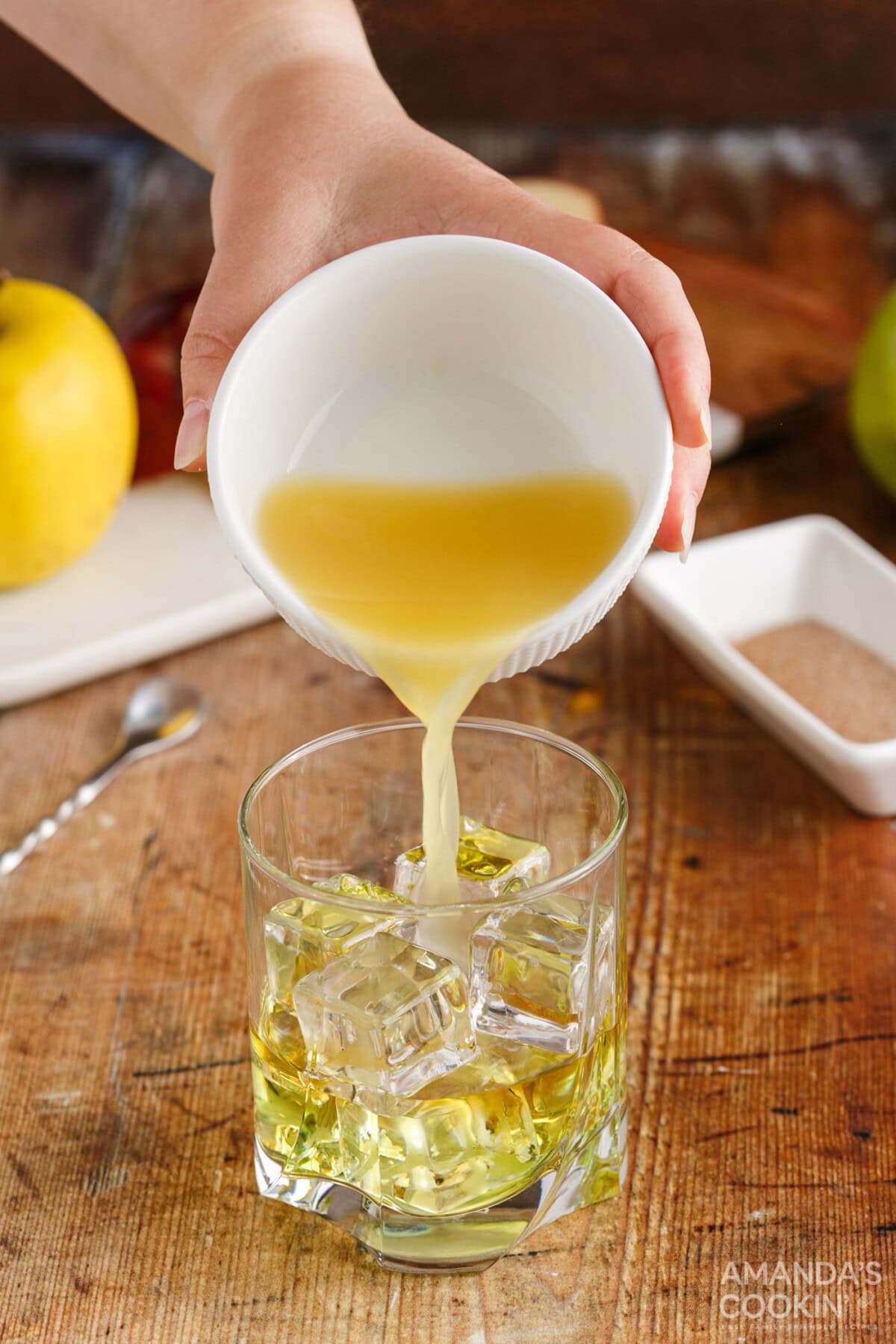 pouring pineapple juice into a rock glass