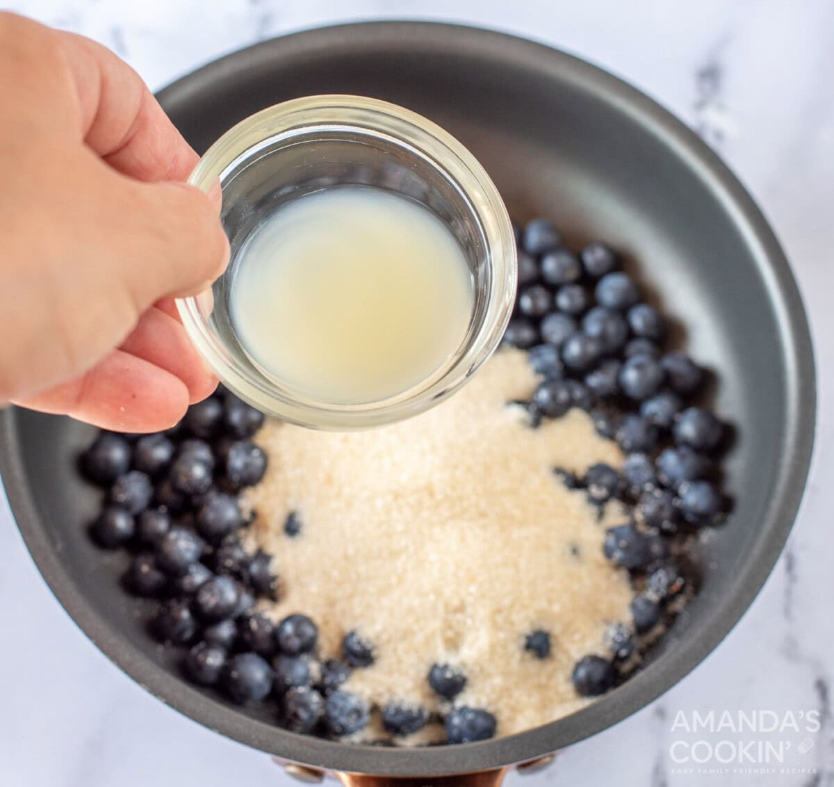 pouring lemon juice into blueberry mixture