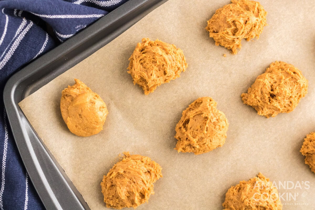 pumpkin cookie dough spooned onto a baking sheet