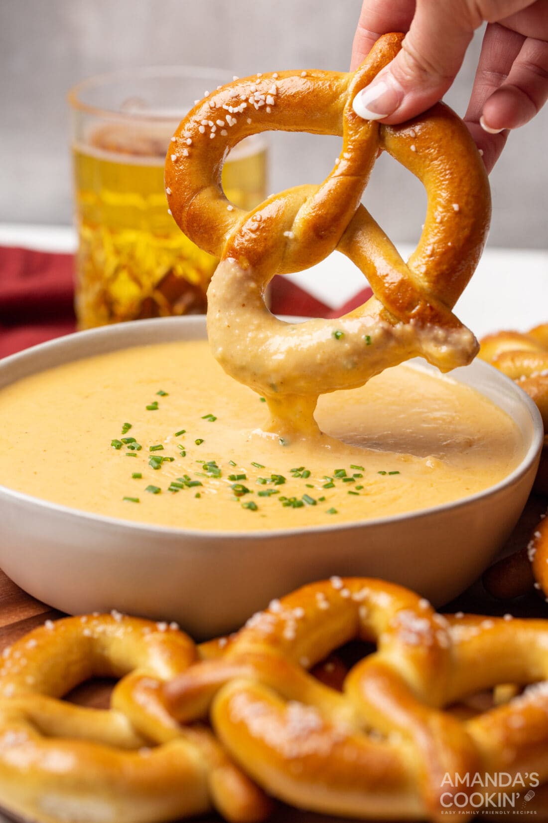 dipping pretzel in beer cheese dip