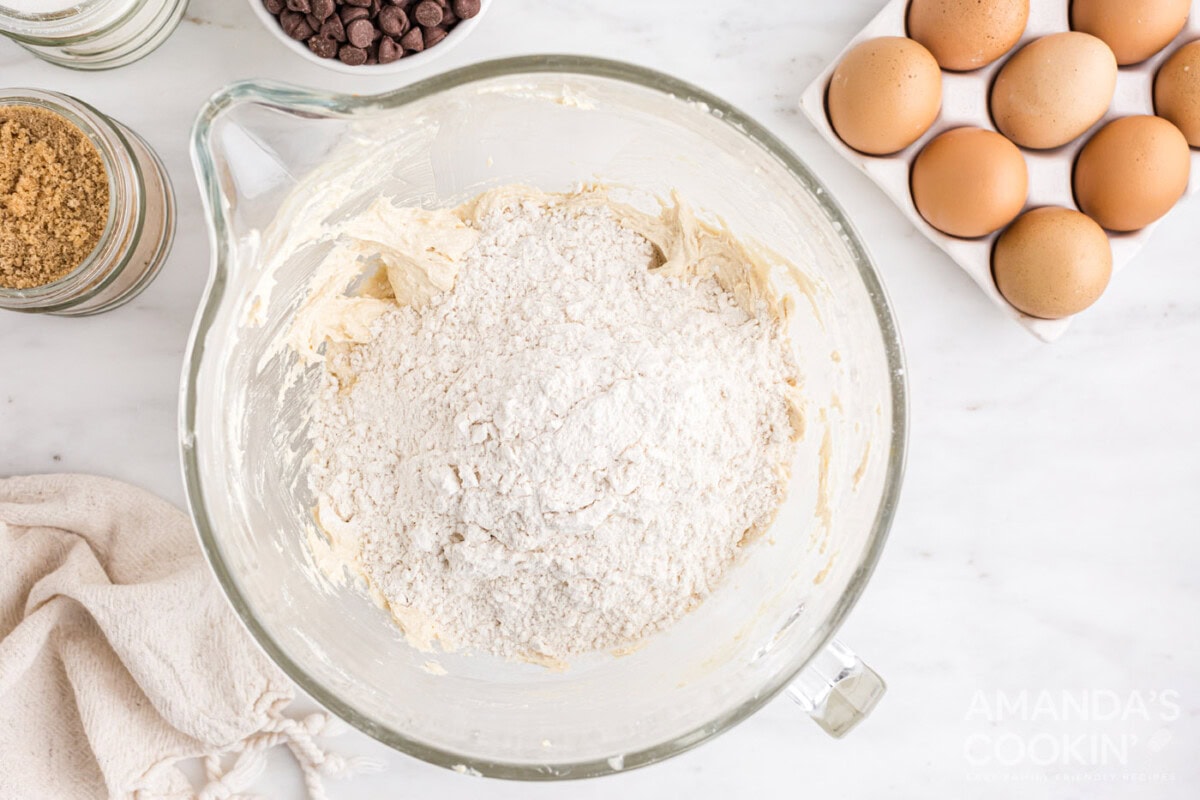 flour mixture added to cookie dough in a bowl