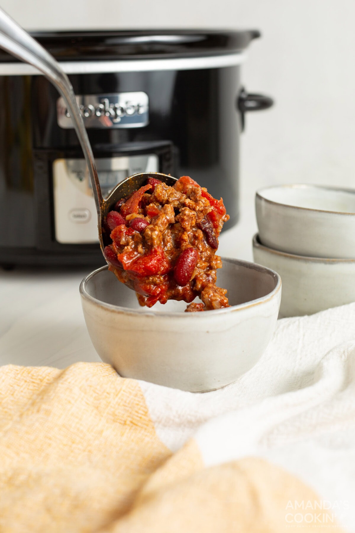 spooning Crockpot Chili into bowl
